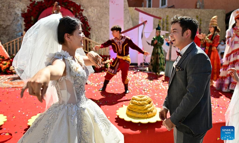 A newlywed couple dances after a group wedding at the Xinjiang International Grand Bazaar in Urumqi, northwest China's Xinjiang Uygur Autonomous Region, Aug. 10, 2024. The group wedding was held here on Saturday to mark the Qixi Festival, also known as Chinese Valentine's Day. Photo: Xinhua