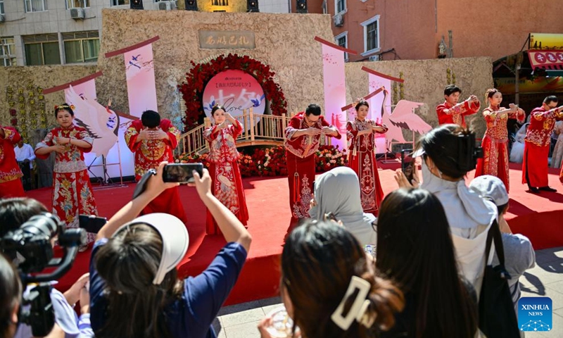 URUMQI, Aug. 10, 2024 (Xinhua) -- Newlywed couples attend a group wedding at the Xinjiang International Grand Bazaar in Urumqi, northwest China's Xinjiang Uygur Autonomous Region, Aug. 10, 2024. The group wedding was held here on Saturday to mark the Qixi Festival, also known as Chinese Valentine's Day. Photo: Xinhua