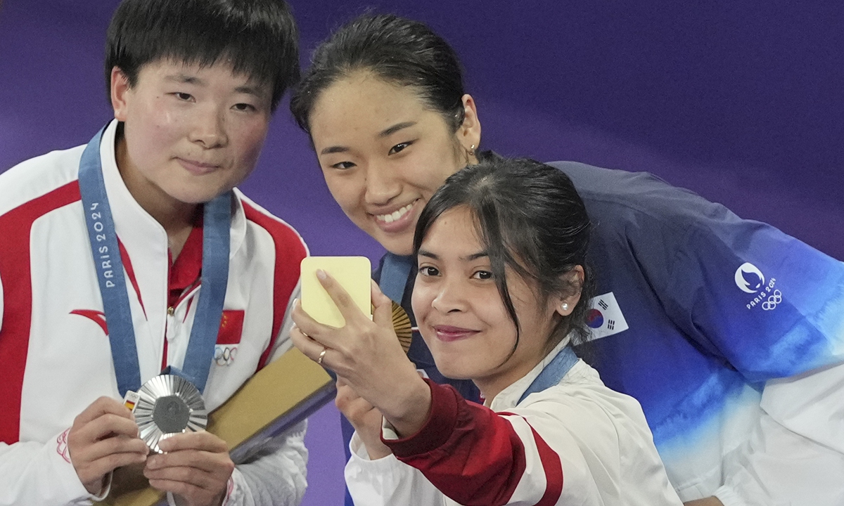 Chinese badminton singles shuttler He Bingjiao (left) carries a badge with the Spanish Olympic Committee onto the podium when He was awarded a silver medal in Paris on August 5. Photo: VCG