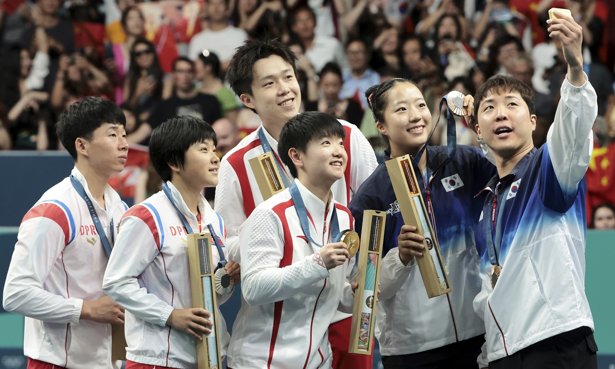 From left, North Korea's Ri Jong-sik and Kim Kum-yong, China's Wang Chuqin and Sun Yingsha, and South Korea's Shin Yu-bin and Lim Jong-hoon pose for a group selfieh after the table tennis mixed doubles final match in Paris on July 30, 2024. Photo: VCG