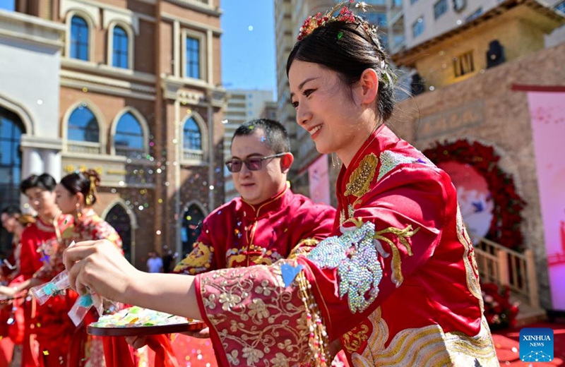 A newlywed couple distributes sweets during a group wedding at the Xinjiang International Grand Bazaar in Urumqi, northwest China's Xinjiang Uygur Autonomous Region, Aug. 10, 2024. The group wedding was held here on Saturday to mark the Qixi Festival, also known as Chinese Valentine's Day. Photo: Xinhua