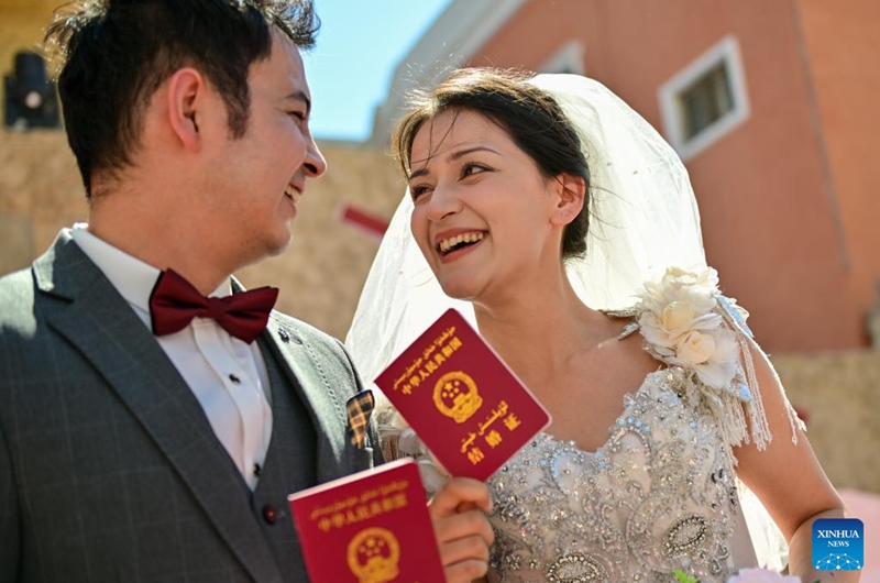 A newly-wed couple attend a group wedding at the Xinjiang International Grand Bazaar in Urumqi, northwest China's Xinjiang Uygur Autonomous Region, Aug. 10, 2024. The group wedding was held here on Saturday on the occasion of the Qixi Festival, also known Chinese Valentine's Day. Photo: Xinhua