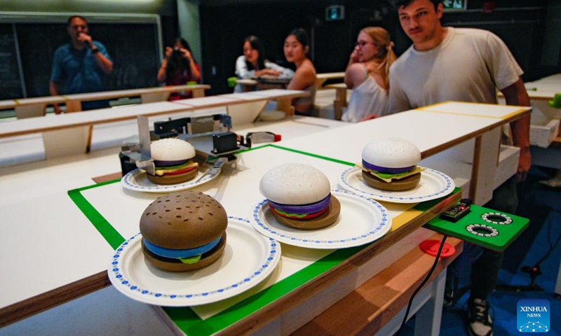 An Engineering Physics student watches his robot in action during a robot competition at the University of British Columbia (UBC) in Vancouver, British Columbia, Canada, on Aug. 8, 2024. Fifteen student teams from UBC participated in a robot competition on Thursday. Each team built a pair of robots to tackle rapid food preparation challenges, aiming to complete as many food orders as possible within the time limit. (Photo: Xinhua)