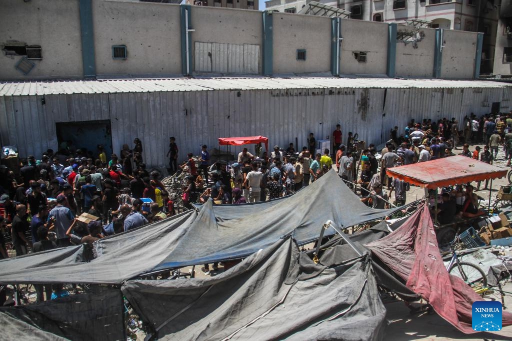 People gather to receive food aid at Jabalia refugee camp in the north of the Gaza Strip, on Aug. 8, 2024. The World Food Programme (WFP) warned that hostilities, damaged roads, and the lack of public order and safety severely hamper food transport operations in Gaza, forcing reduced rations. WFP urgently needs fuel deliveries, an increased flow of food supplies and a greater capacity to deliver hot meals, particularly in Gaza City and North Gaza. (Photo: Xinhua)