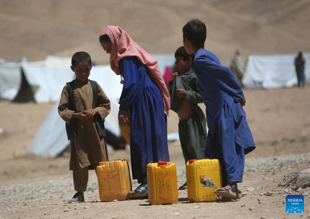 Children with water barrels are seen at a relocation site for flood survivors in Firoz Koh, Ghor province, Afghanistan, July 27, 2024. (Photo: Xinhua)