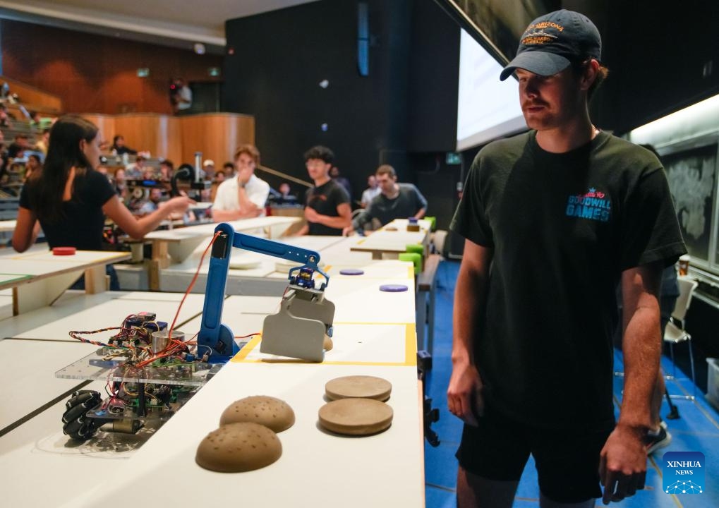 An Engineering Physics student watches his robot in action during a robot competition at the University of British Columbia (UBC) in Vancouver, British Columbia, Canada, on Aug. 8, 2024. Fifteen student teams from UBC participated in a robot competition on Thursday. Each team built a pair of robots to tackle rapid food preparation challenges, aiming to complete as many food orders as possible within the time limit. (Photo: Xinhua)