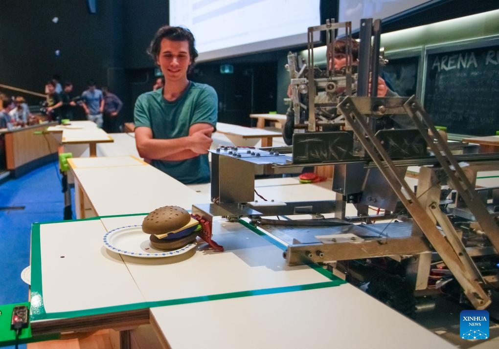 Engineering Physics students watch their robot in action during a robot competition at the University of British Columbia (UBC) in Vancouver, British Columbia, Canada, on Aug. 8, 2024. Fifteen student teams from UBC participated in a robot competition on Thursday. Each team built a pair of robots to tackle rapid food preparation challenges, aiming to complete as many food orders as possible within the time limit. (Photo: Xinhua)