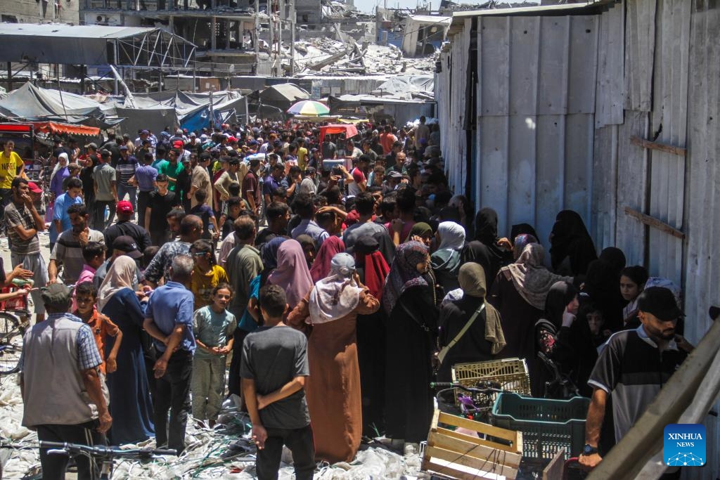 People gather to receive food aid at Jabalia refugee camp in the north of the Gaza Strip, on Aug. 8, 2024. The World Food Programme (WFP) warned that hostilities, damaged roads, and the lack of public order and safety severely hamper food transport operations in Gaza, forcing reduced rations. WFP urgently needs fuel deliveries, an increased flow of food supplies and a greater capacity to deliver hot meals, particularly in Gaza City and North Gaza. (Photo: Xinhua)