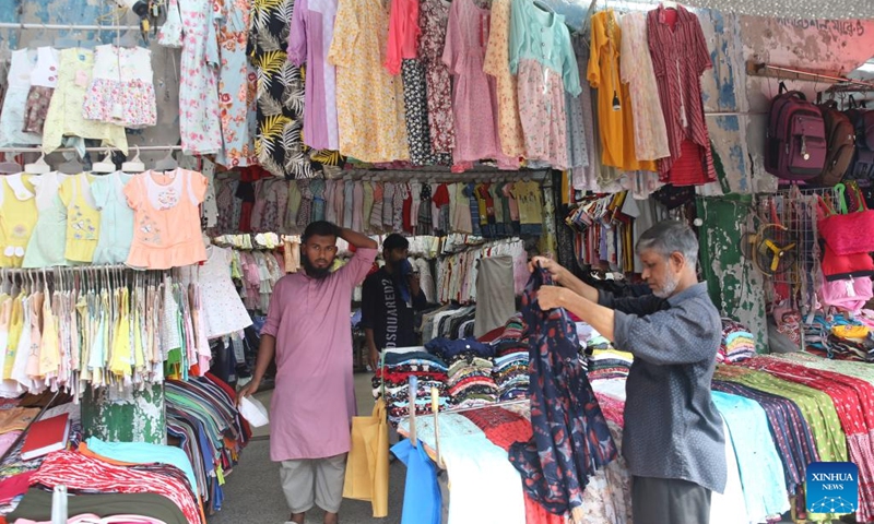 A man selects clothes on a street in Dhaka, Bangladesh, Aug. 9, 2024. Bangladeshi economist Muhammad Yunus took oath as the head of the country's interim government here on Thursday. Photo: Xinhua