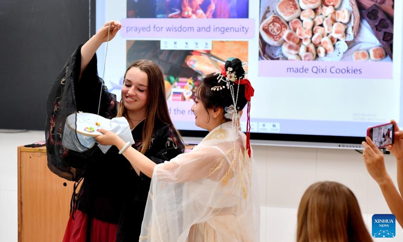 An American student experiences Qixi traditions during a cultural event at Shijiazhuang Foreign Language School in Shijiazhuang, north China's Hebei Province, Aug. 10, 2024. A delegation of middle school students and teachers from US state Iowa took part in a cultural event here on the occasion of the Qixi Festival, also known as Chinese Valentine's Day. Photo: Xinhua