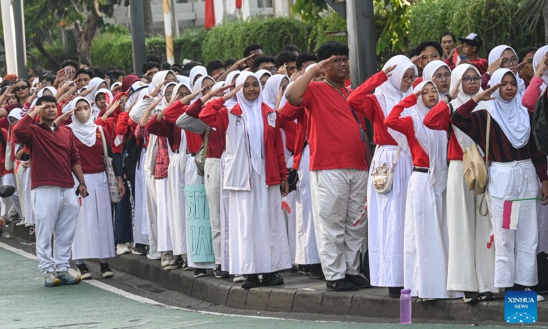 Students pay tribute to a convoy team escorting the replica of a heirloom flag and a copy of the Indonesian Independence Proclamation manuscript in Jakarta, Indonesia, Aug. 10, 2024. The flag and the manuscript copy were transported from the National Monument in Jakarta to Indonesia's New Capital Nusantara located in Kalimantan Island for the 79th anniversary of the country's Independence Day, which falls on Aug. 17. Photo: Xinhua