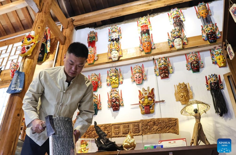 Bao Bo, an inheritor of Anshun woodcarving, makes a Dixi mask in Jiuzhou ancient town scenic area of Anshun City, southwest China's Guizhou Province, July 25, 2024. Photo: Xinhua