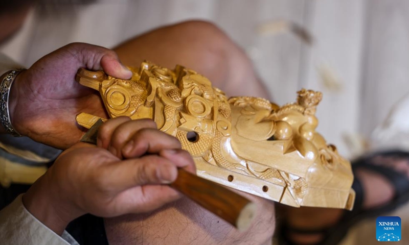 Bao Bo, an inheritor of Anshun woodcarving, makes a Dixi mask in Jiuzhou ancient town scenic area of Anshun City, southwest China's Guizhou Province, July 25, 2024. Photo: Xinhua