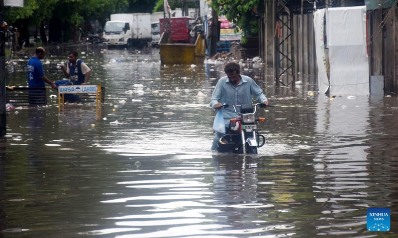 People wade through floodwater in a street after heavy monsoon rain in Lahore, Pakistan on Aug. 11, 2024. Photo: Xinhua