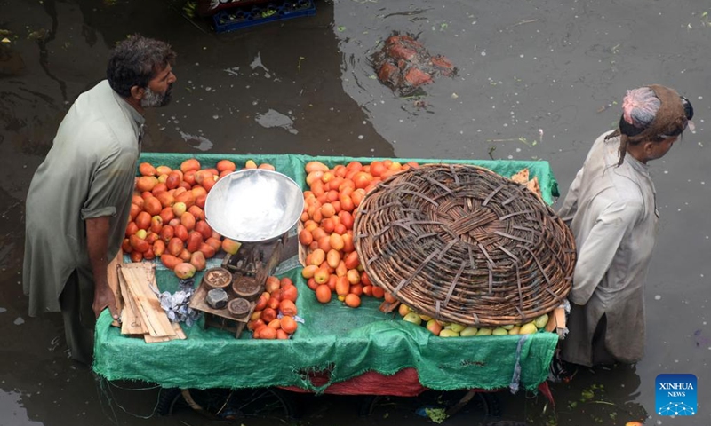 People move a stall at a flooded fruit and vegetable market after heavy monsoon rain in Lahore, Pakistan on Aug. 11, 2024. Photo: Xinhua