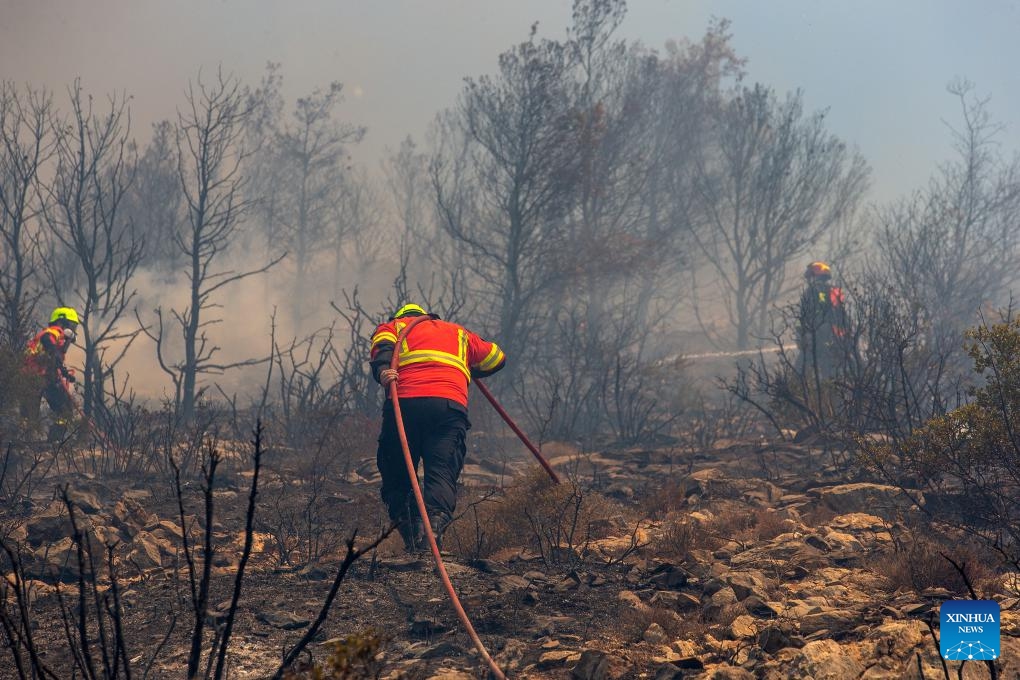 Firefighters try to extinguish a wildfire in Attica, Greece, on Aug. 12, 2024. （Photo: Xinhua)