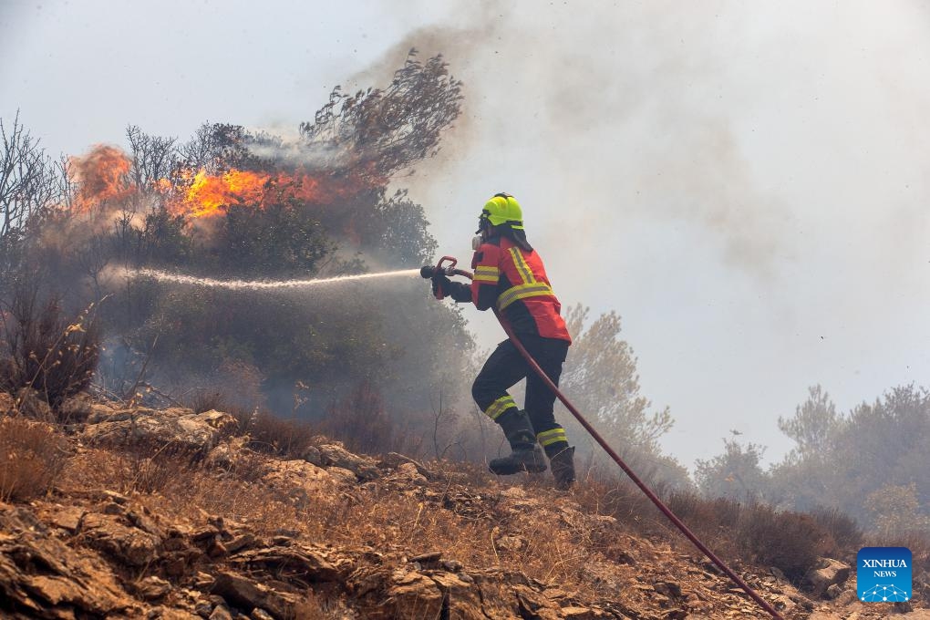 Firefighters try to extinguish a wildfire in Attica, Greece, on Aug. 12, 2024. （Photo: Xinhua)