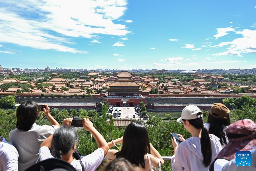 Tourists take pictures of the Palace Museum from Jingshan Park on a sunny day in Beijing,<strong></strong> capital of China, Aug. 12, 2024. （Photo: Xinhua)