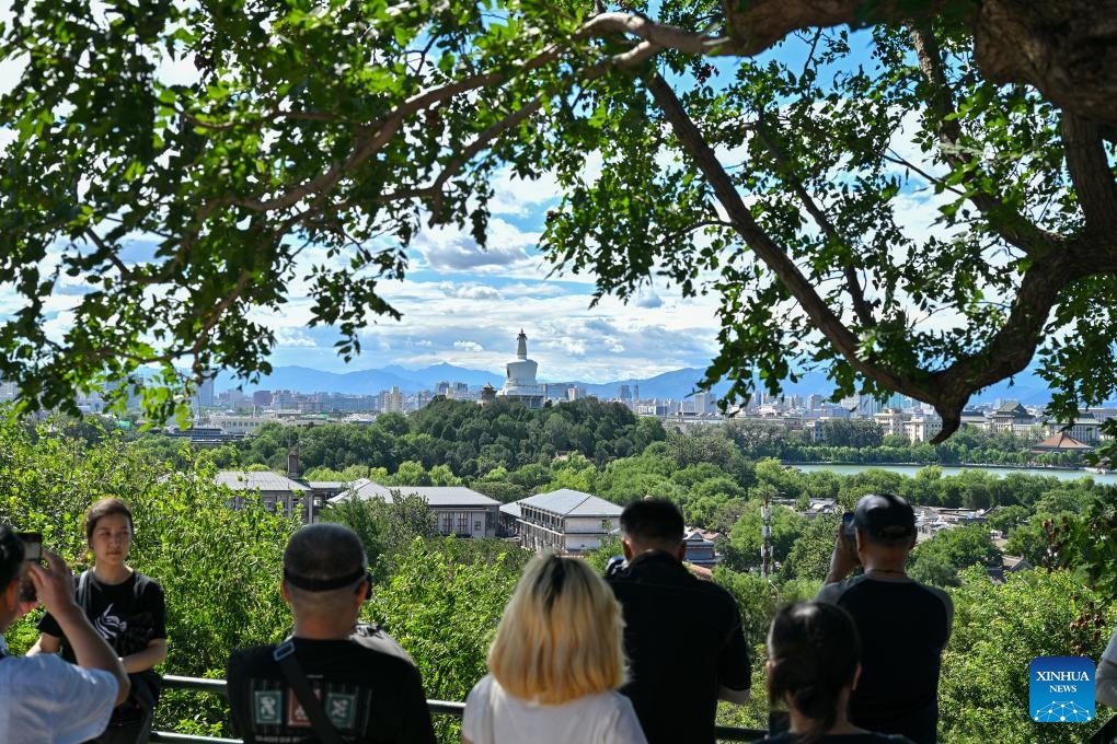 Tourists take pictures of Beihai Park from Jingshan Hill on a sunny day in Beijing, capital of China, Aug. 12, 2024. （Photo: Xinhua)