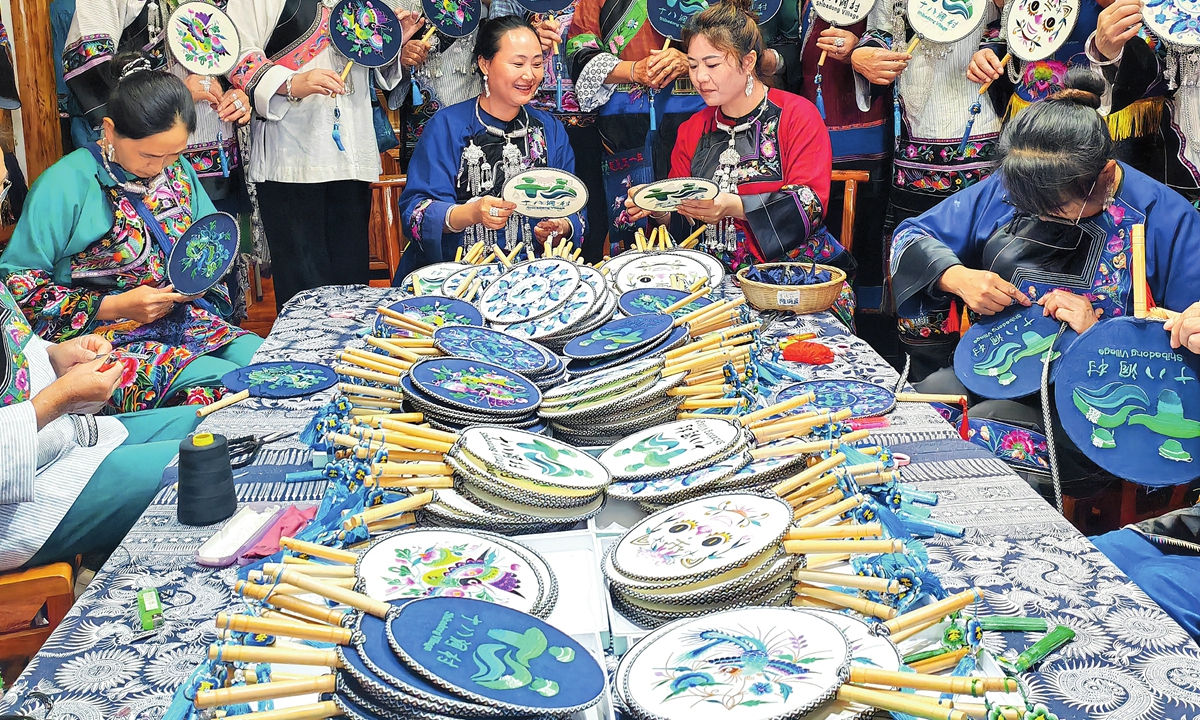 Residents from Shibadong village show traditional embroidery works. Photo: Courtesy of China Rural Revitalization magazine