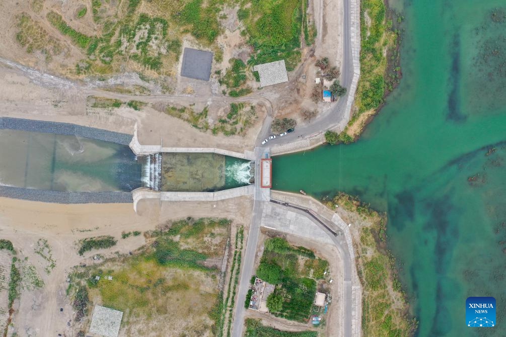 An aerial drone photo taken on Aug. 12, 2024 shows water flowing from the Daxihaizi Reservoir into the river course in Yuli County, northwest China's Xinjiang Uygur Autonomous Region. Northwest China's Xinjiang Uygur Autonomous Region on Monday began discharging water from a reservoir into the Tarim River, China's longest inland river, as part of an ongoing ecological conservation project in the region. （Photo: Xinhua)