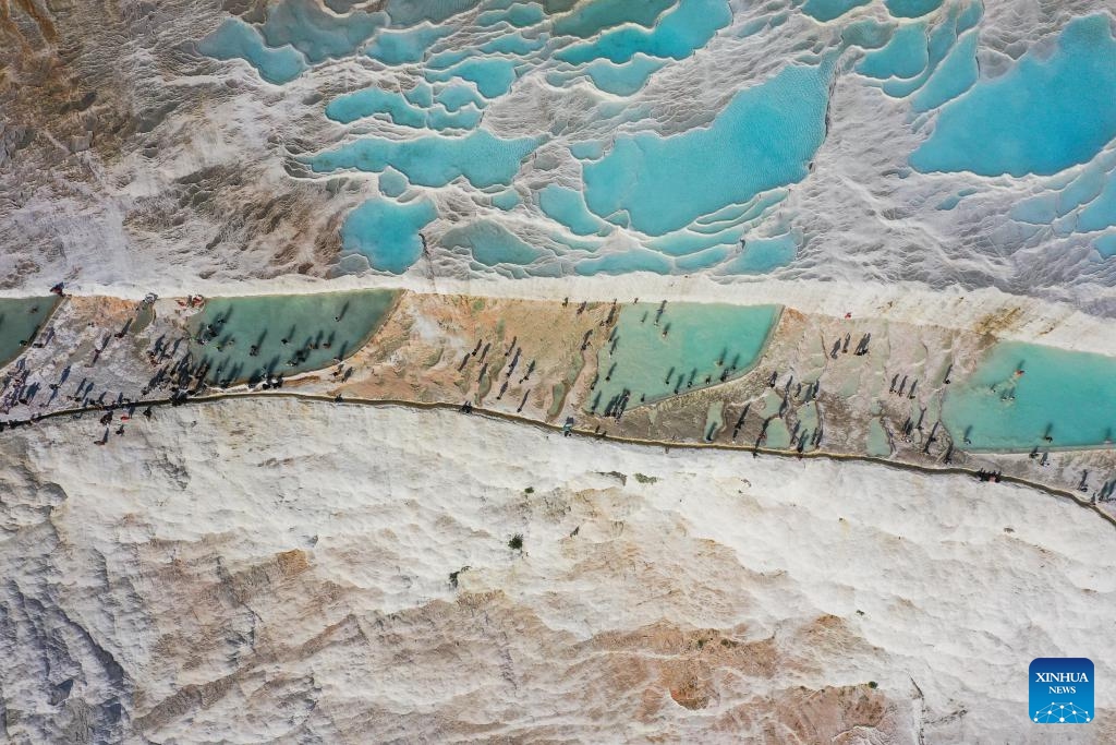 An aerial drone photo taken on Aug. 10, 2024 shows a scene of Pamukkale in Denizli, Türkiye. Pamukkale, or Cotton Castle, is a main Turkish tourist attraction known for its white travertine made up of natural calcified waterfalls and a series of terraced basins. (Photo: Xinhua)