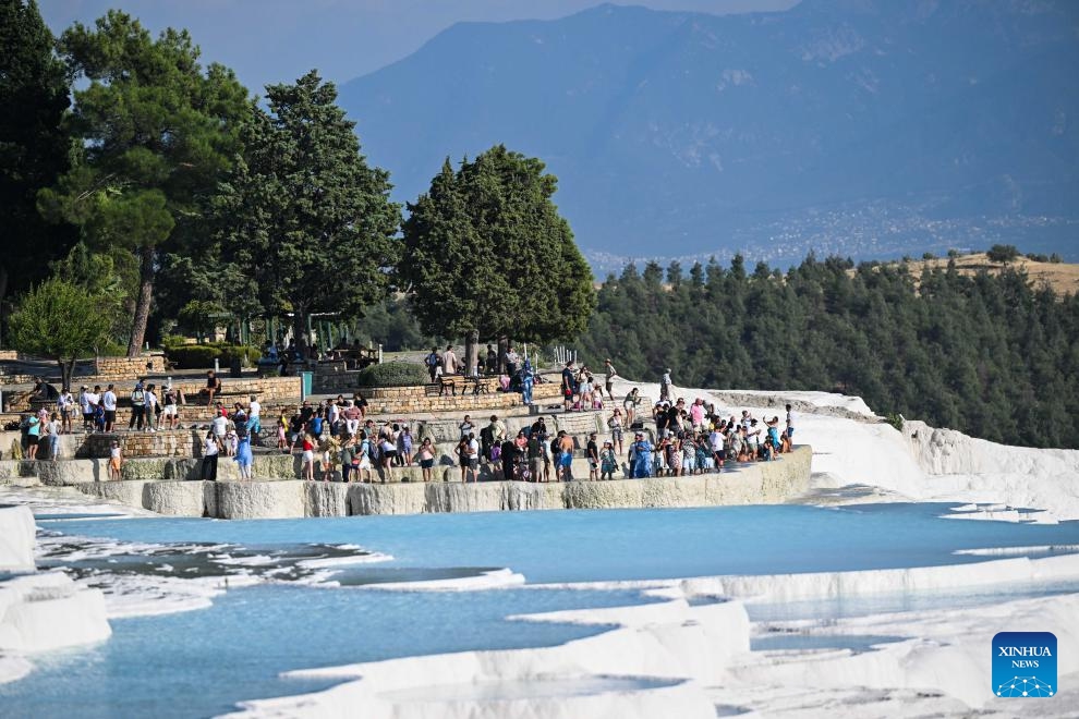 Tourists visit Pamukkale in Denizli, Türkiye, Aug. 10, 2024. Pamukkale, or Cotton Castle, is a main Turkish tourist attraction known for its white travertine made up of natural calcified waterfalls and a series of terraced basins. (Photo: Xinhua)