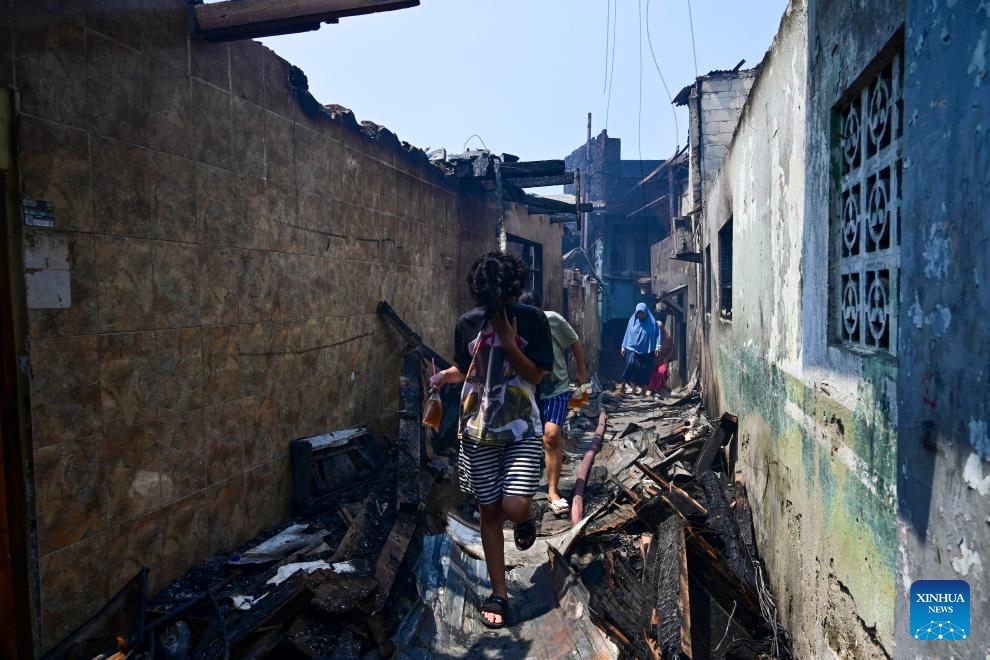 Residents walk among charred houses after a fire at densely populated area in Manggarai of Jakarta, Indonesia, Aug. 13, 2024. (Photo: Xinhua)