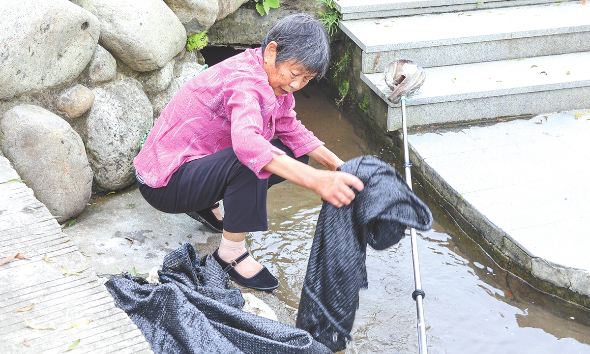 A villager picks up rubbish from the river in Xinjian Village in Zhoushan, East China's Zhejiang Province.