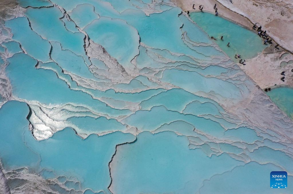 An aerial drone photo taken on Aug. 11, 2024 shows a scene of Pamukkale in Denizli, Türkiye. Pamukkale, or Cotton Castle, is a main Turkish tourist attraction known for its white travertine made up of natural calcified waterfalls and a series of terraced basins. (Photo: Xinhua)