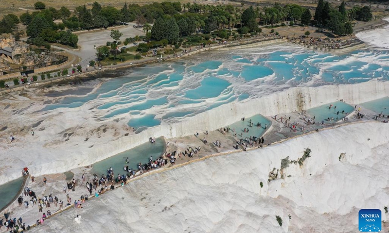 An aerial drone photo taken on Aug. 11, 2024 shows a scene of Pamukkale in Denizli, Türkiye. Pamukkale, or Cotton Castle, is a main Turkish tourist attraction known for its white travertine made up of natural calcified waterfalls and a series of terraced basins. (Photo: Xinhua)