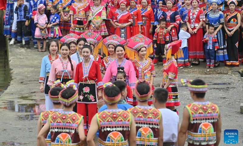 Villagers sing folk songs in a call-and-response style on a stone pathway over a river in Wangdong Township of Rongshui Miao Autonomous County in south China's Guangxi Zhuang Autonomous Region, Aug. 18, 2024. In recent years, Wangdong Township has leveraged its abundant water resources to promote rural vitalization. Supported by the pairing assistance from Lianjiang City in Guangdong Province, the township has organized water sports competitions, mountain song duets, and activities under the theme of intangible cultural heritage in schools. These initiatives aim to build a water culture brand and advance the development of ethnic cultural tourism. Photo: Xinhua