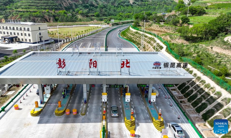 This aerial drone photo taken on Aug. 16, 2024 shows vehicles running past the Pengyang north toll gate to Yinchuan-Kunming highway in Pengyang County of Guyuan City, northwest China's Ningxia Hui Autonomous Region. A section of the Yinchuan-Kunming highway within Ningxia, from Taiyangshan development zone to Pengyang, was completed and opened to traffic on Friday, marking the full opening of the Yinchuan-Kunming highway. The highway linking Yinchuan of northwest China's Ningxia Hui Autonomous Region and Kunming of southwest China's Yunnan Province, spans 2322 kilometers. Photo: Xinhua