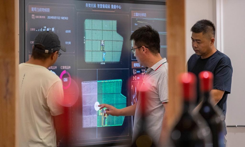 A winery staff member (C) demonstrates a smart data screen to tourists at a winery in Yinchuan, northwest China's Ningxia Hui Autonomous Region, Aug. 15, 2024. Photo: Xinhua