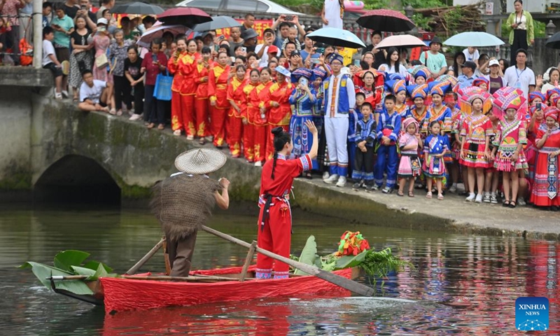 People watch an outdoor performance in Wangdong Township of Rongshui Miao Autonomous County in south China's Guangxi Zhuang Autonomous Region, Aug. 18, 2024. In recent years, Wangdong Township has leveraged its abundant water resources to promote rural vitalization. Supported by the pairing assistance from Lianjiang City in Guangdong Province, the township has organized water sports competitions, mountain song duets, and activities under the theme of intangible cultural heritage in schools. These initiatives aim to build a water culture brand and advance the development of ethnic cultural tourism. Photo: Xinhua