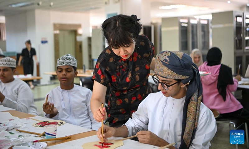 A teacher guides Omani youngsters to try traditional Chinese painting at Tianjin Foreign Studies University in north China's Tianjin Municipality, Aug. 15, 2024. Twenty-two youngsters from Oman are on a two-week study tour in Beijing and Tianjin to experience the Chinese culture. Photo: Xinhua