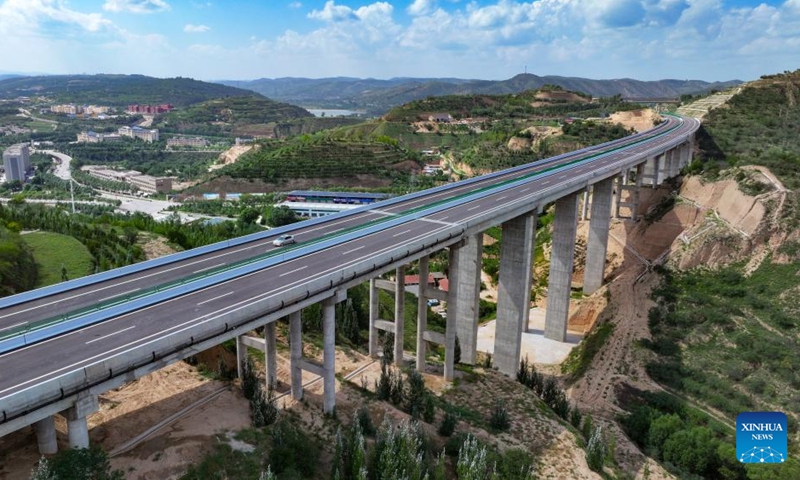 This aerial drone photo taken on Aug. 16, 2024 shows a vehicle running along the Yinchuan-Kunming highway in northwest China's Ningxia Hui Autonomous Region. A section of the Yinchuan-Kunming highway within Ningxia, from Taiyangshan development zone to Pengyang, was completed and opened to traffic on Friday, marking the full opening of the Yinchuan-Kunming highway. The highway linking Yinchuan of northwest China's Ningxia Hui Autonomous Region and Kunming of southwest China's Yunnan Province, spans 2322 kilometers. Photo: Xinhua