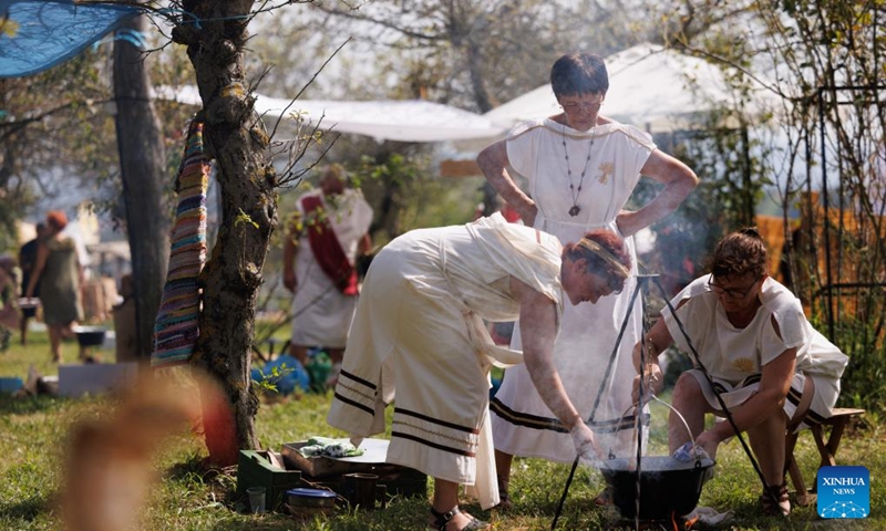 Participants dressed in Roman costumes prepare the Roman pot dish during the Roman Games in Ptuj, Slovenia, Aug. 17, 2024. The Roman Games, one of the largest presentations of the Roman period in Slovenia, was held in Ptuj on Saturday. Photo: Xinhua