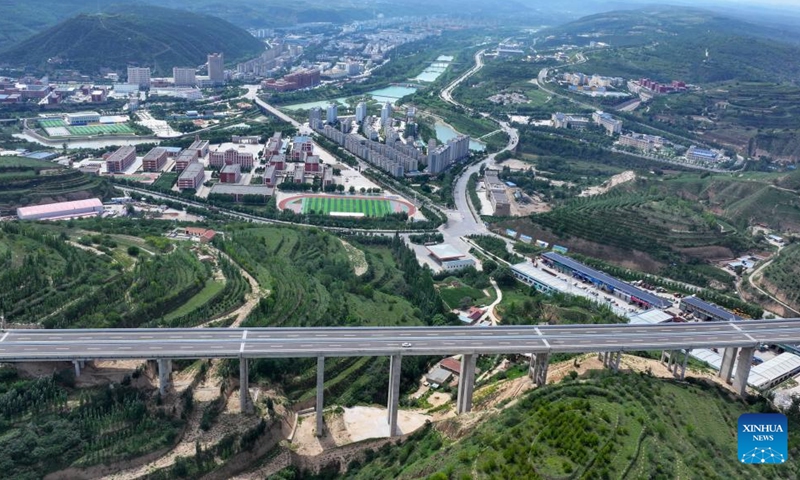 This aerial drone photo taken on Aug. 16, 2024 shows a vehicle running along the Yinchuan-Kunming highway with the Pengyang County in the background in northwest China's Ningxia Hui Autonomous Region. A section of the Yinchuan-Kunming highway within Ningxia, from Taiyangshan development zone to Pengyang, was completed and opened to traffic on Friday, marking the full opening of the Yinchuan-Kunming highway. The highway linking Yinchuan of northwest China's Ningxia Hui Autonomous Region and Kunming of southwest China's Yunnan Province, spans 2322 kilometers. Photo: Xinhua