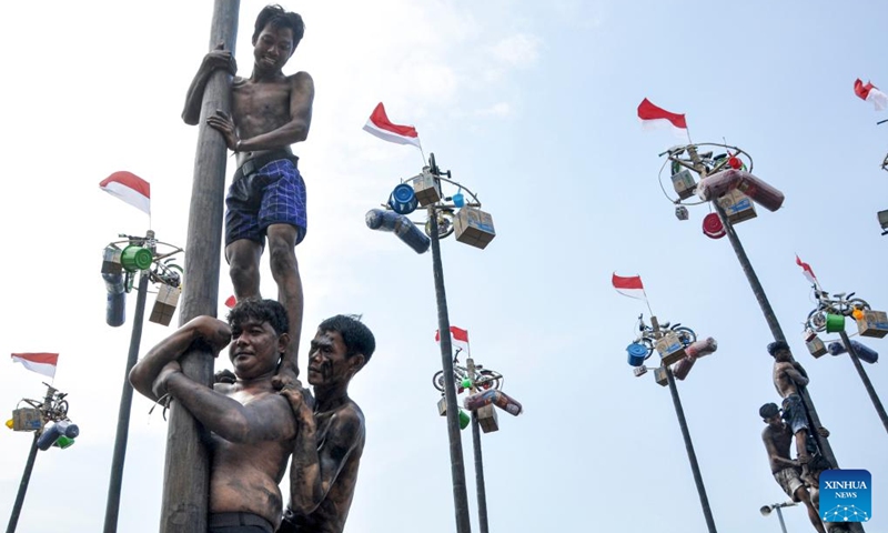 People participate in a greasy pole climbing game during the celebration of the 79th Independence Day at Ancol beach in Jakarta, Indonesia, Aug. 17, 2024. Indonesia celebrated its 79th Independence Day on Saturday. Photo: Xinhua