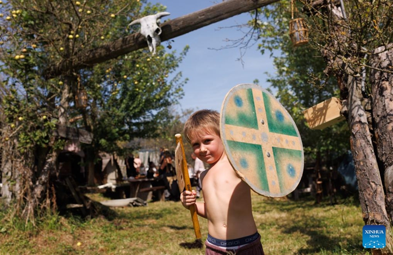 A little participant holding prop arms poses for photos during the Roman Games in Ptuj, Slovenia, Aug. 17, 2024. The Roman Games, one of the largest presentations of the Roman period in Slovenia, was held in Ptuj on Saturday. Photo: Xinhua