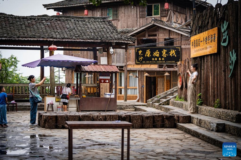 A tourist poses for a photo at a scenic spot in Basha Village, Congjiang County of Qiandongnan Miao and Dong Autonomous Prefecture, southwest China's Guizhou Province, Aug. 16, 2024. Photo: Xinhua