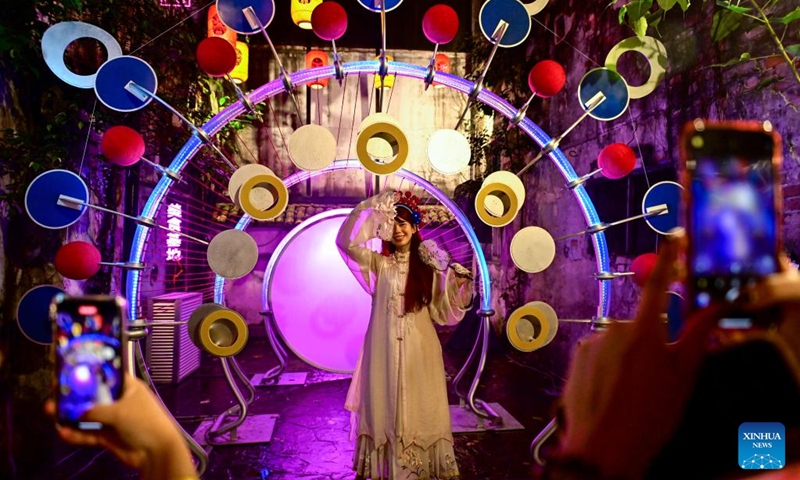 A tourist poses for photos in front of an installation marking the Mid-Autumn Festival in Kuala Lumpur, Malaysia, Aug. 15, 2024. Photo: Xinhua