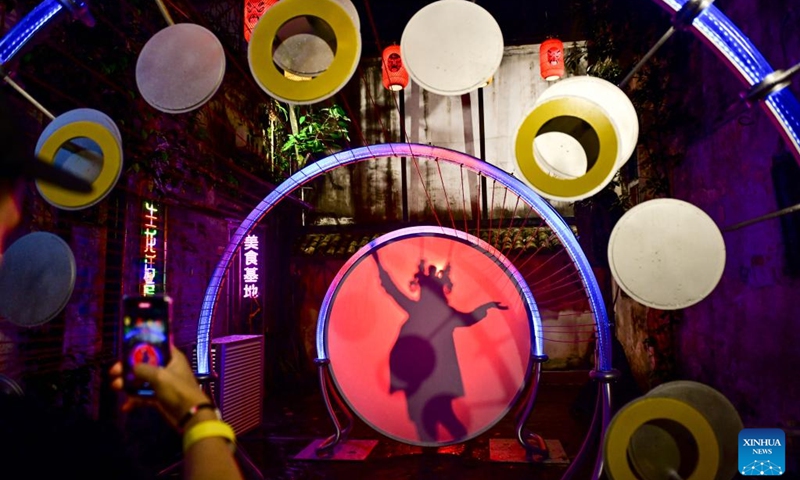 A tourist poses for photos behind an installation marking the Mid-Autumn Festival in Kuala Lumpur, Malaysia, Aug. 15, 2024. Photo: Xinhua