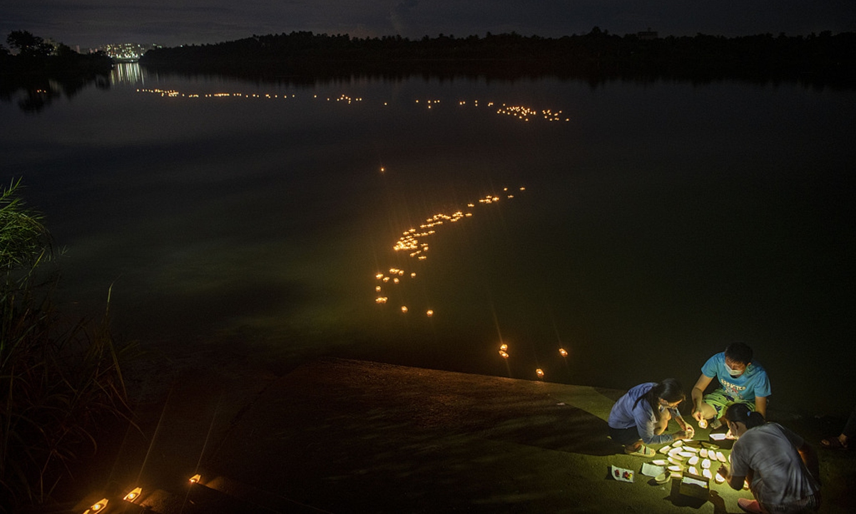 People in Qionghai City, South China's Hainan Province, release floating water lanterns in the Wanquan River, to celebrate the Zhongyuan Festival on August 12, 2022. Photo: VCG