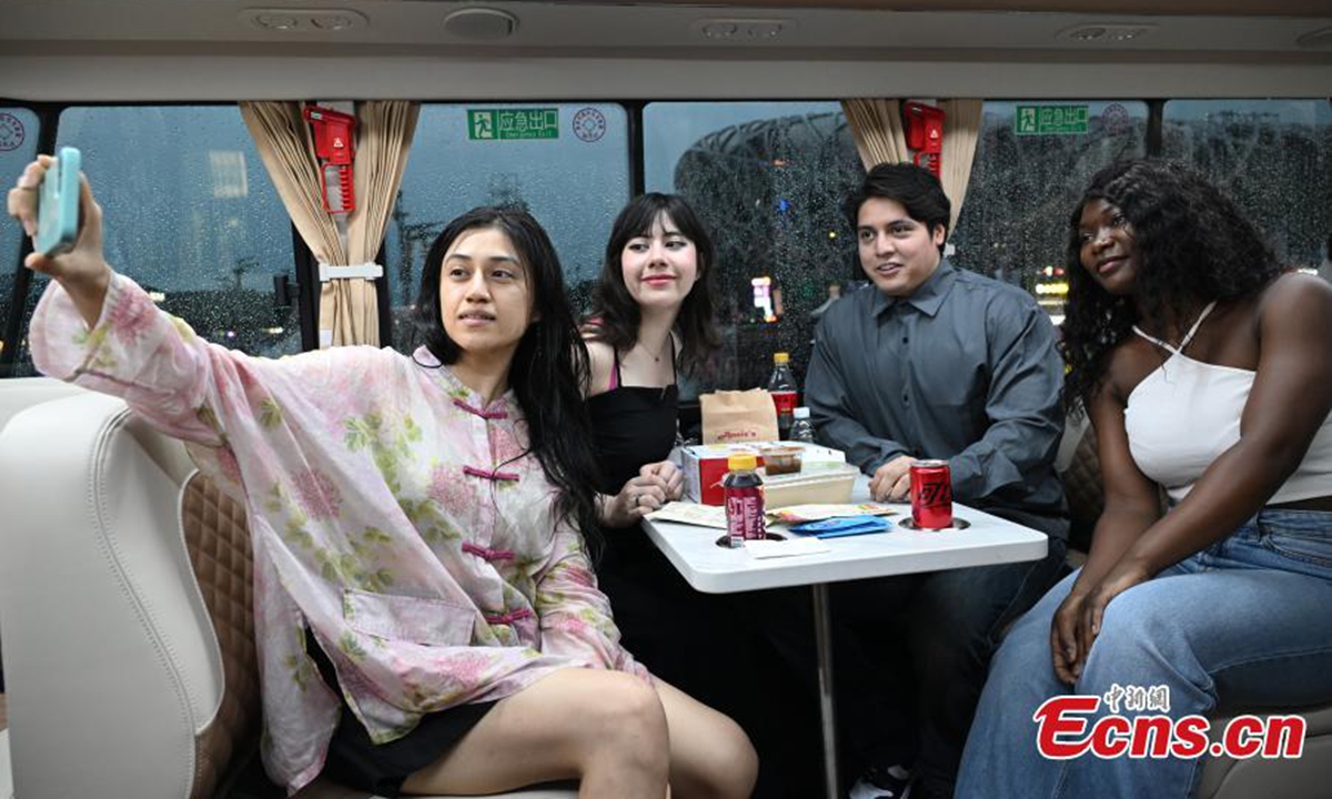 Passengers enjoy night view on a sightseeing bus in Beijing, Aug. 18, 2024. Photo: China News Service
