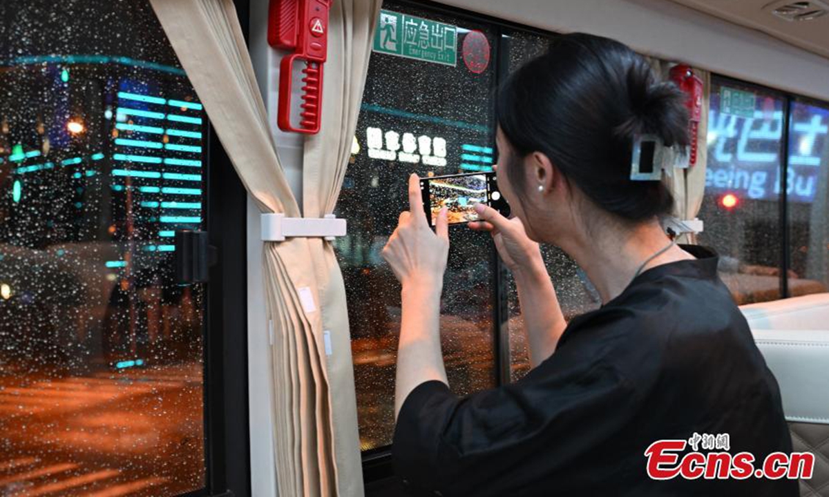 Passengers enjoy night view on a sightseeing bus in Beijing, Aug. 18, 2024. Photo: China News Service
