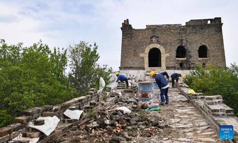 Workers repair walls near a defense tower of the Jiankou section of the Great Wall in Beijing, capital of China, July 2, 2024. Covering six defense towers, from No. 117 to No. 122, the fifth phase of the Jiankou section of the Great Wall repair project has progressed smoothly. Beijing has pioneered Great Wall archaeological research, which precedes the repair work. The Jiankou section and the Dazhuangke section in Yanqing District have been selected as pilot projects to promote research-oriented restoration and protection of the Great Wall. Photo: Xinhua