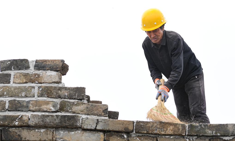 A worker sweeps the top of a wall near a defense tower of the Jiankou section of the Great Wall in Beijing, capital of China, July 2, 2024. Covering six defense towers, from No. 117 to No. 122, the fifth phase of the Jiankou section of the Great Wall repair project has progressed smoothly. Beijing has pioneered Great Wall archaeological research, which precedes the repair work. The Jiankou section and the Dazhuangke section in Yanqing District have been selected as pilot projects to promote research-oriented restoration and protection of the Great Wall. Photo: Xinhua