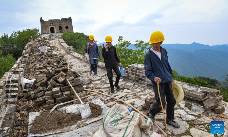 Workers walk on the Jiankou section of the Great Wall in Beijing, capital of China, July 2, 2024. Covering six defense towers, from No. 117 to No. 122, the fifth phase of the Jiankou section of the Great Wall repair project has progressed smoothly. Beijing has pioneered Great Wall archaeological research, which precedes the repair work. The Jiankou section and the Dazhuangke section in Yanqing District have been selected as pilot projects to promote research-oriented restoration and protection of the Great Wall. Photo: Xinhua